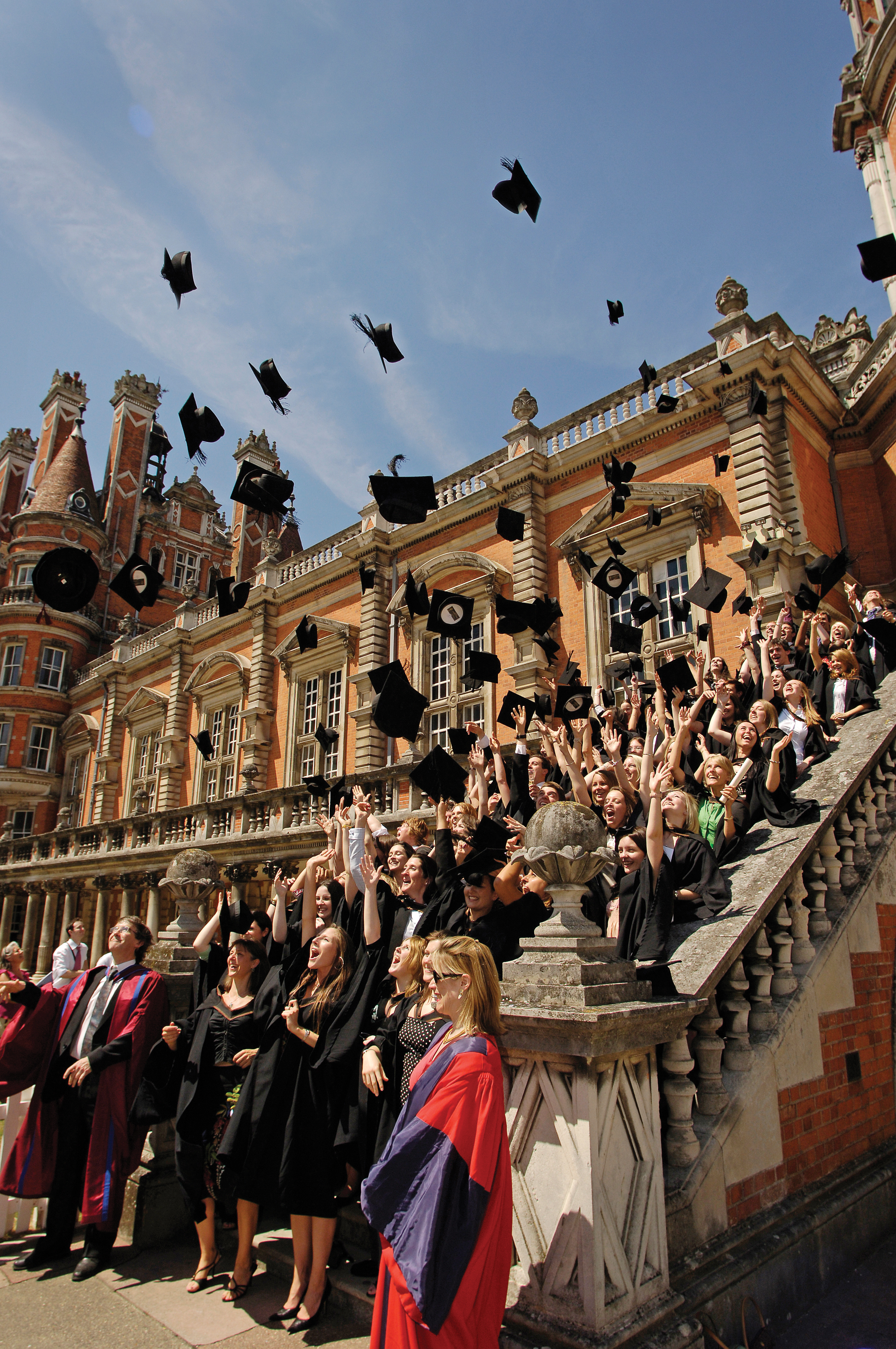 Graduates on Founder's squad steps throwing their caps in the air